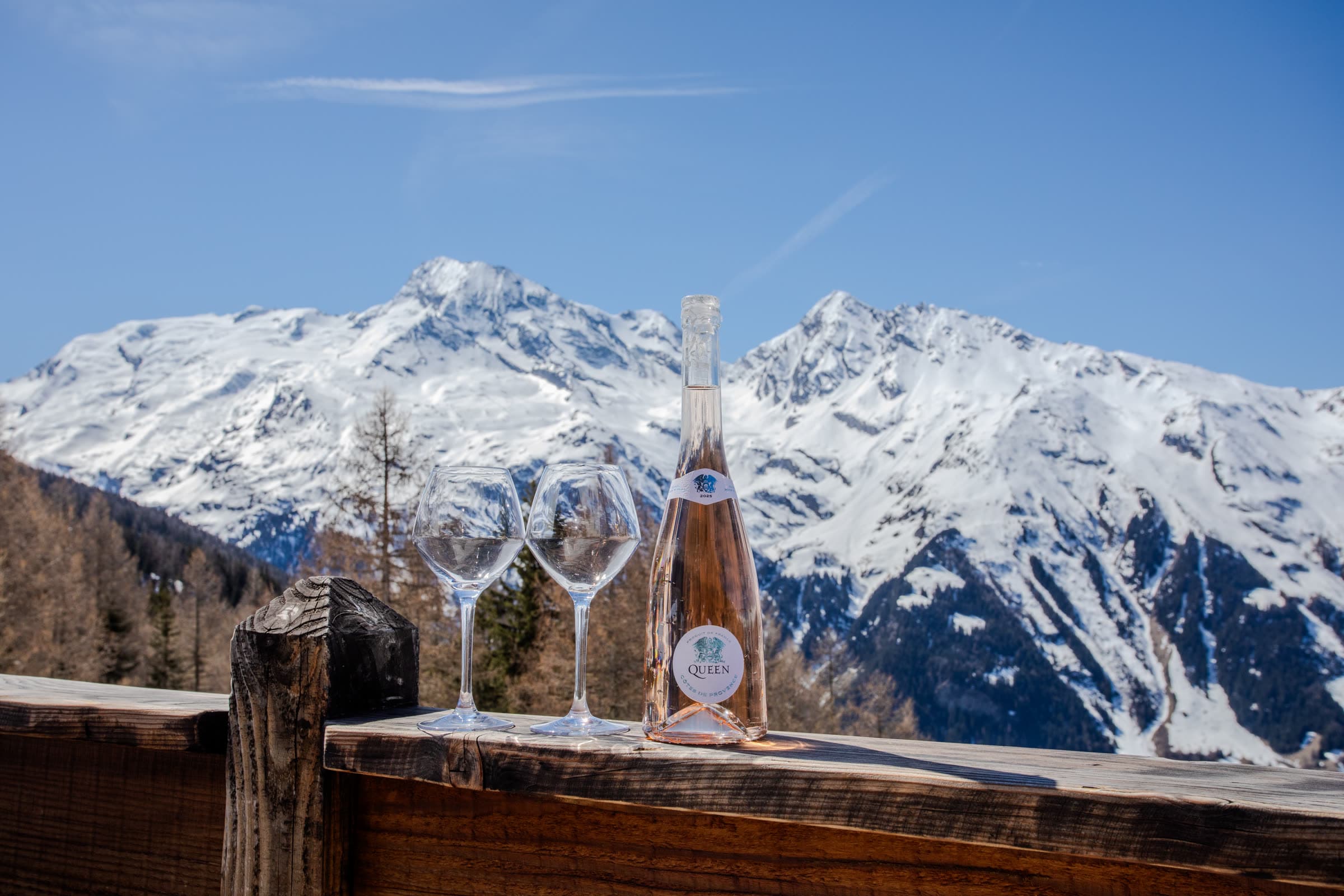 Queen Côtes De Provence Rosé bottle and glasses against the Provençal mountains